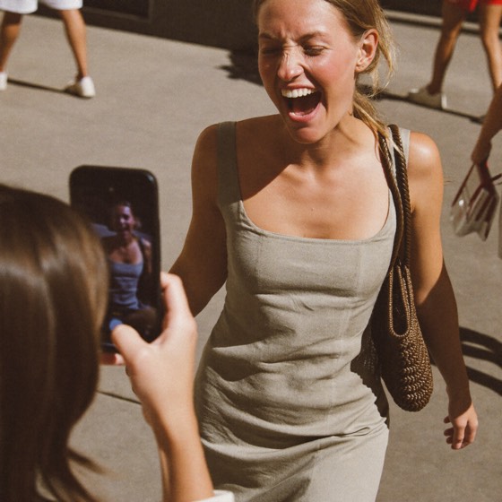 Creadora posando en la calle mientras su amiga le toma la foto